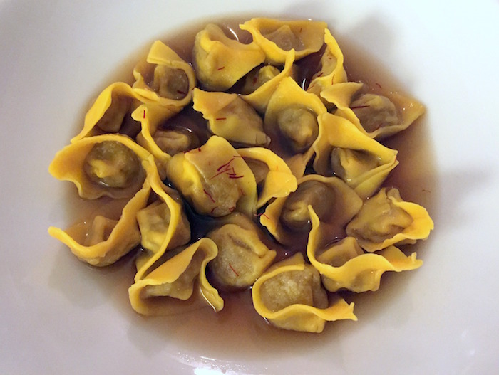 Il piatto più audace: Raviolini di cipolla caramellata in brodo di bucce di patata bruciate e infusione di porcini secchi